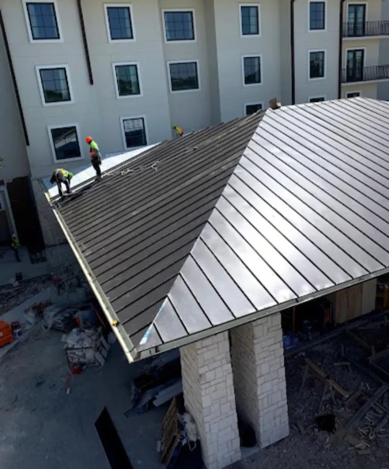 Crew installing standing seam metal roof panels on a commercial project in St. Helena